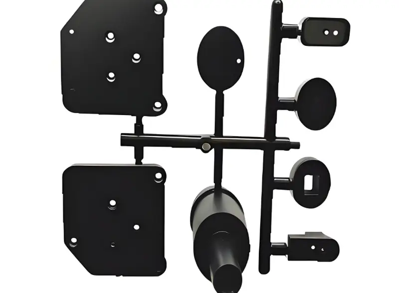 Black injection molded product parts on white background