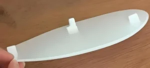 A curved plastic piece with clips, often used as a light diffuser in appliances.