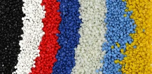 Siyah, beyaz, kırmızı, mavi, açık yeşil, açık mavi ve sarı dahil olmak üzere dikey şeritler halinde düzenlenmiş çeşitli renklerde plastik peletler.