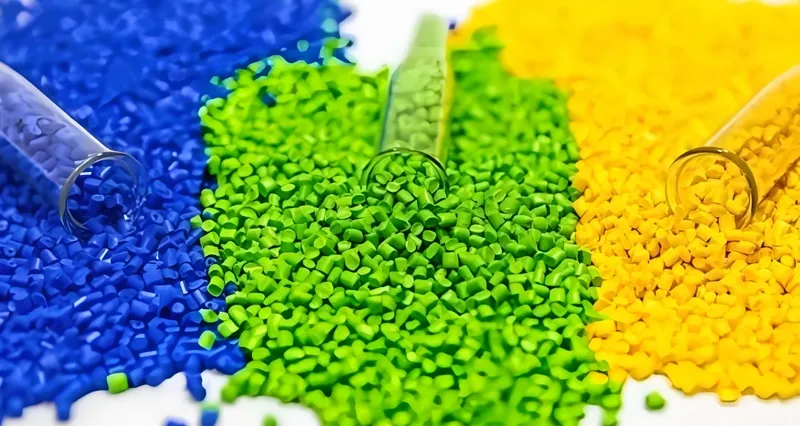 Close-up van blauwe, groene en gele plastic polymeerkorrels uit glazen reageerbuizen