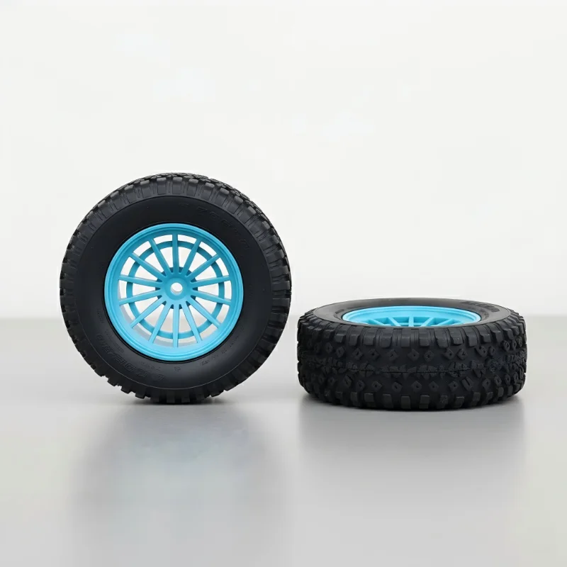 Black tire with blue wheel standing next to another lying flat on the surface.