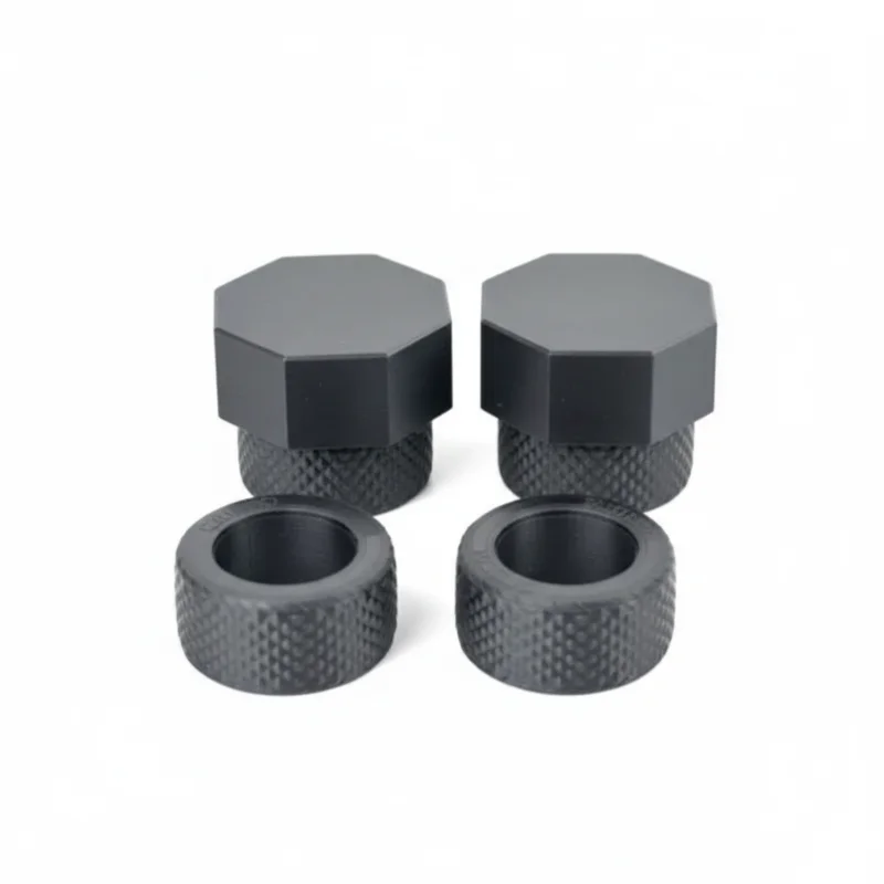 Four black plastic knurled caps and rings with a textured surface, on a white background.