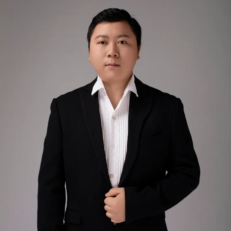 Person in a black suit and white shirt, showcasing formal business attire.