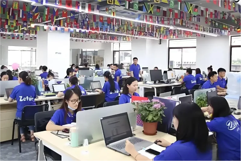 Office with team collaboration, decorated with international flags, showcasing a dynamic workplace environment.