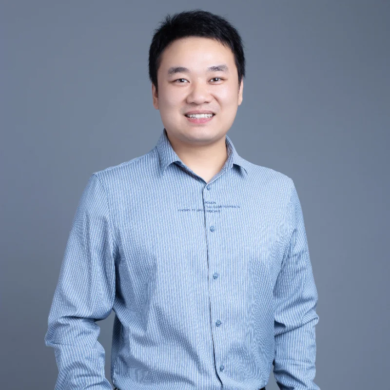 Individual wearing a blue striped shirt with a blurred face against a neutral background.