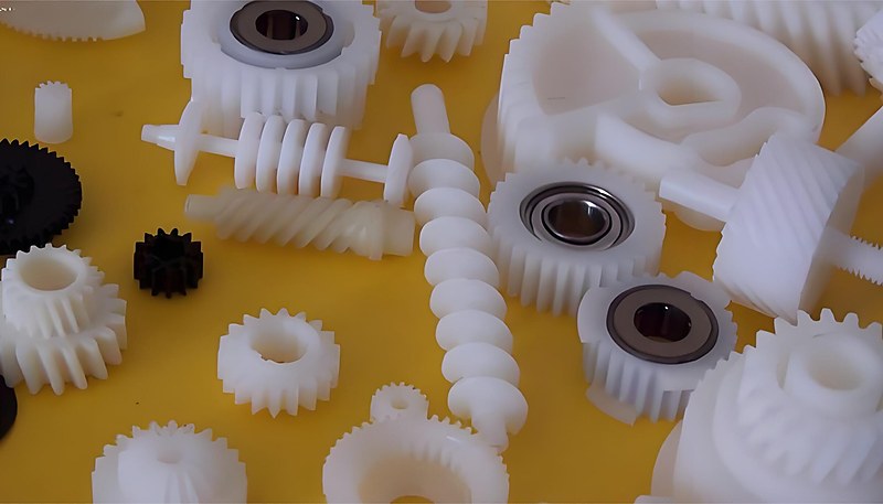 Various metal insert types including brass threaded bushings, stainless steel pins, and knurled inserts before molding