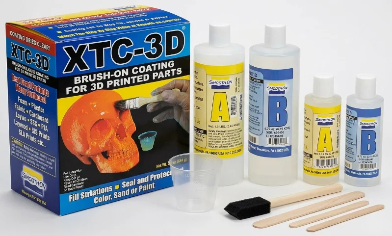 XTC-3D brush-on coating kit for 3D printed parts with bottles, brush, stir sticks.