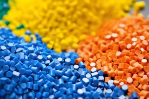 Primer plano de bolitas de polímero de colores surtidos en azul, naranja y amarillo.