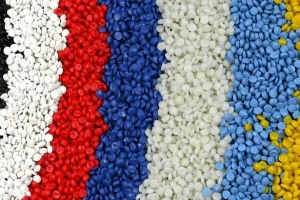 Siyah, beyaz, kırmızı, mavi, açık yeşil, açık mavi ve sarı dahil olmak üzere dikey şeritler halinde düzenlenmiş çeşitli renklerde plastik peletler.