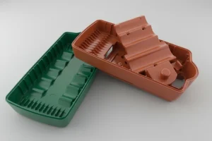 Green and brown plastic injection molded parts showcasing intricate design and precision engineering.