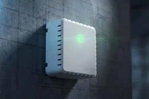 Smart home device mounted on a gray wall with glowing green indicator light.